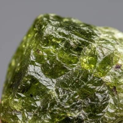 Close-up macro photograph of raw Peridot gemstone crystal